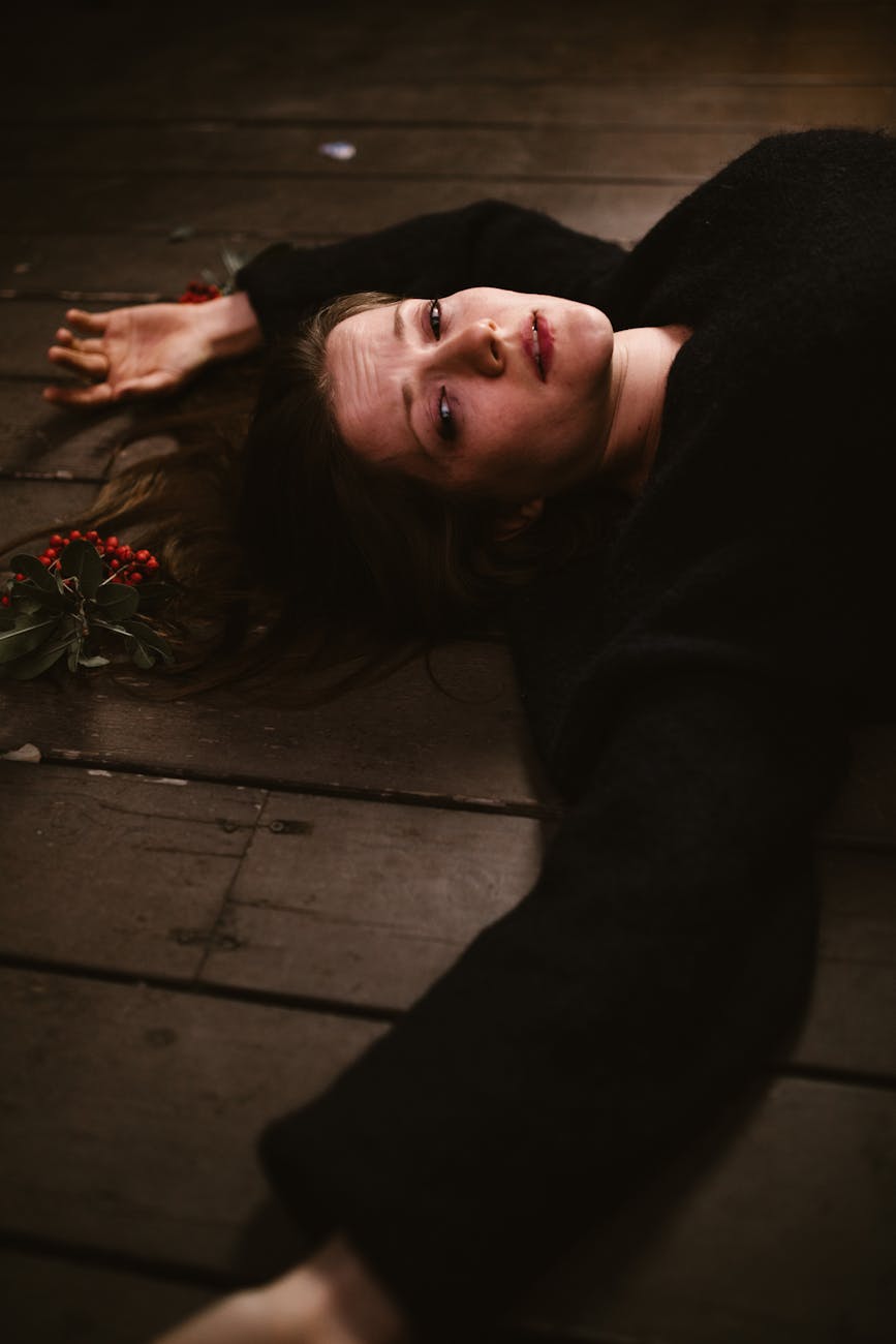 depressed woman lying on brown wooden floor